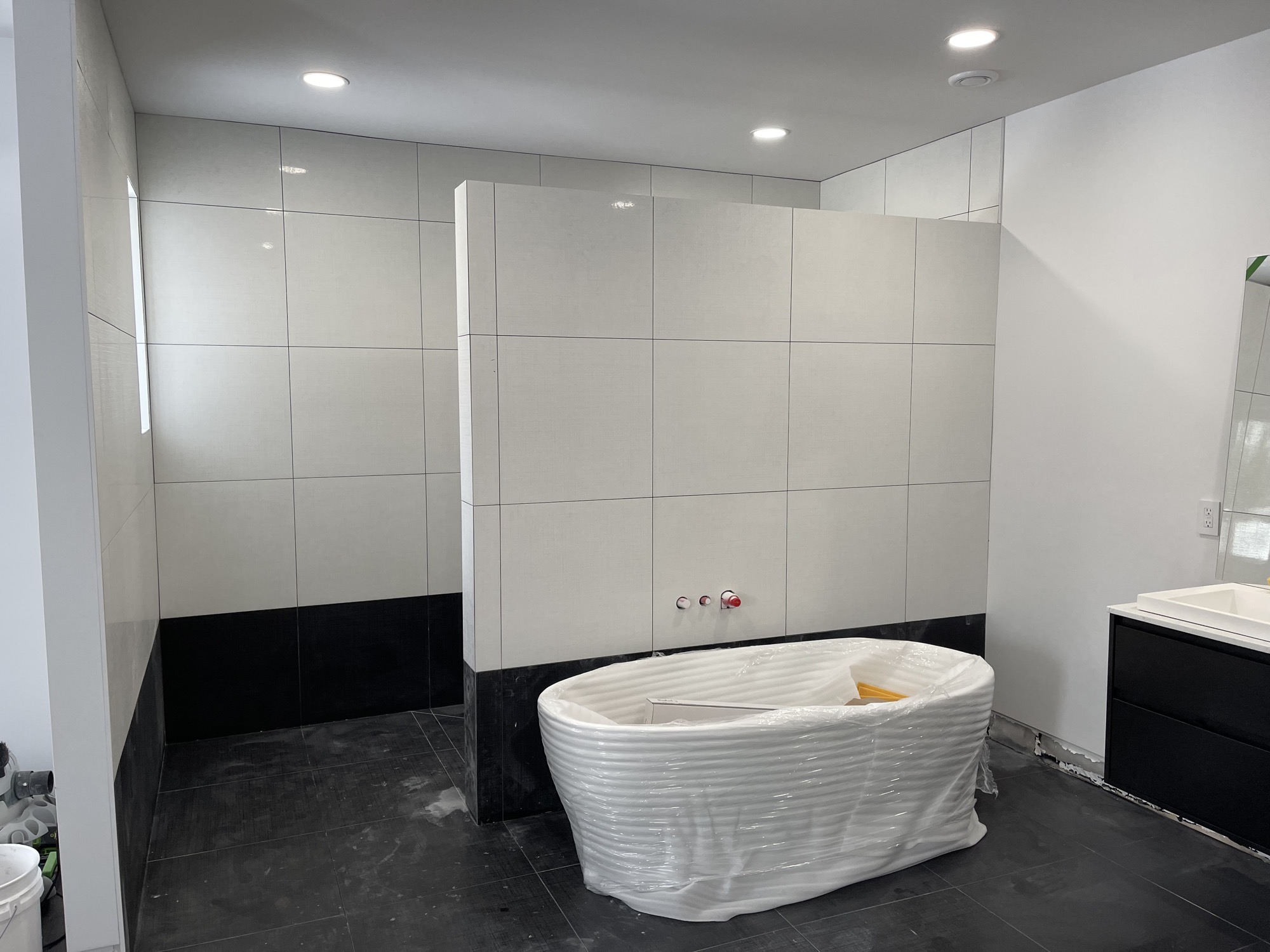 Elegant bathroom tub with large tiles.