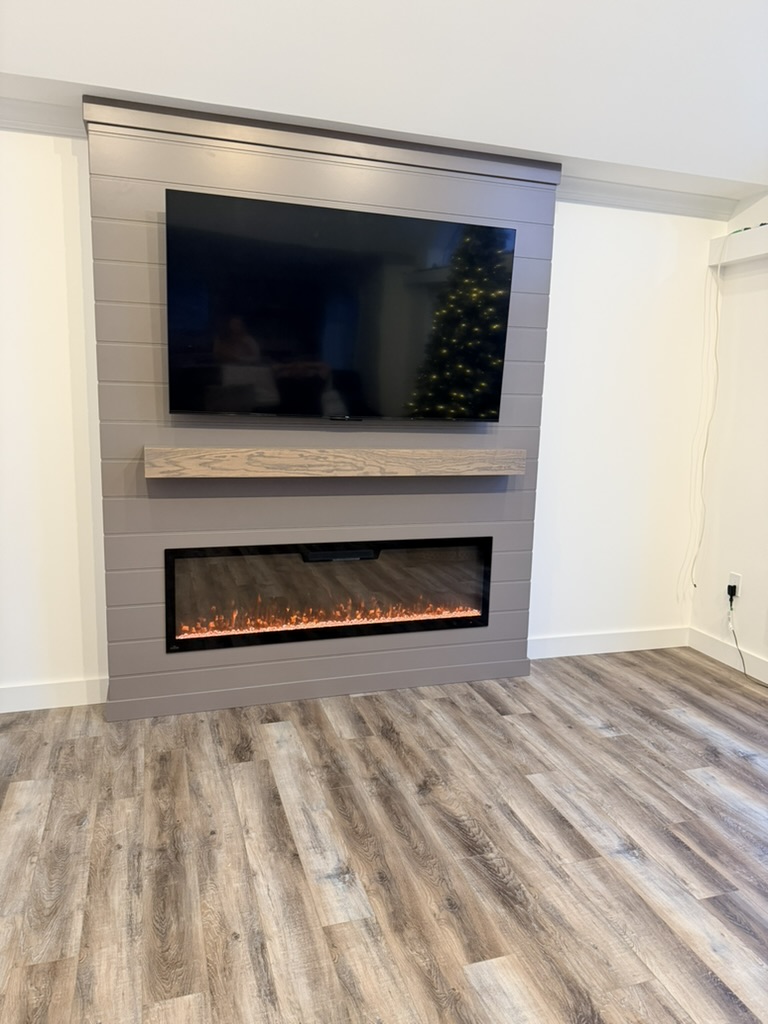 Electric fireplace mantel with TV.